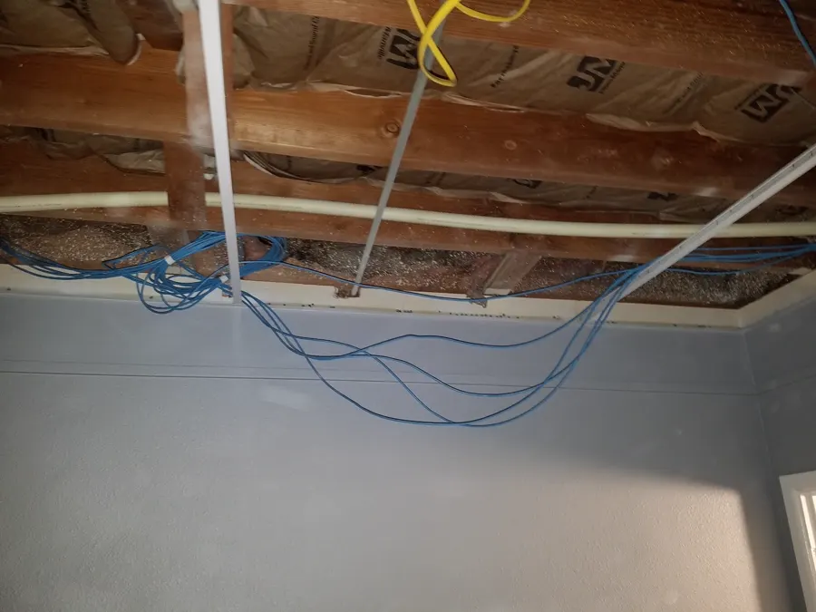 Cables strung through an open ceiling cavity during a wiring job.