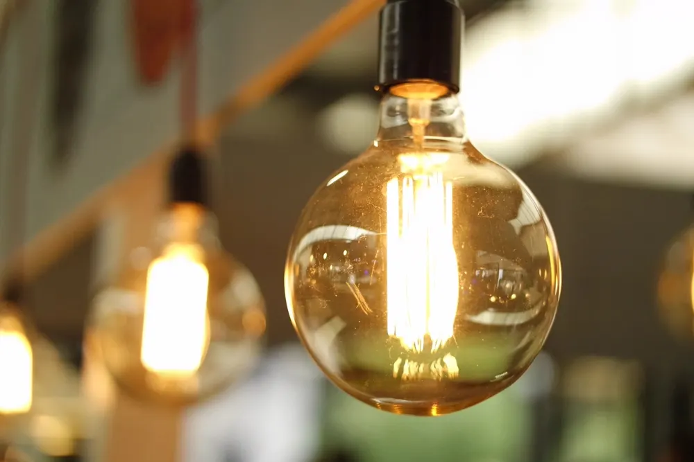 Stock photo: a glowing filament bulb on a dark background.